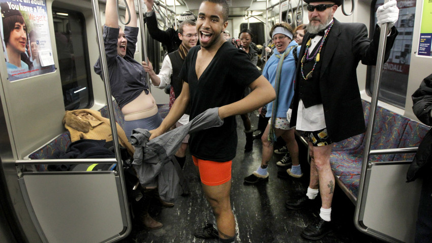 Cambridge, MA 1/09/11- Marques Hollie (cq) takes his shirt and pants off during the 4th annual No Pants Subway Ride in Boston was held today starting from the Alewife Red Line stop in Cambridge. The event is organized by the Societies of Spontaneity and is a global event started by www.ImprovEverywhere.com in New York in 2002. Hailey Fuqua (cq) at left, Paul McCarthy (cq) at right. (Globe staff photo/Bill Greene) section:metro